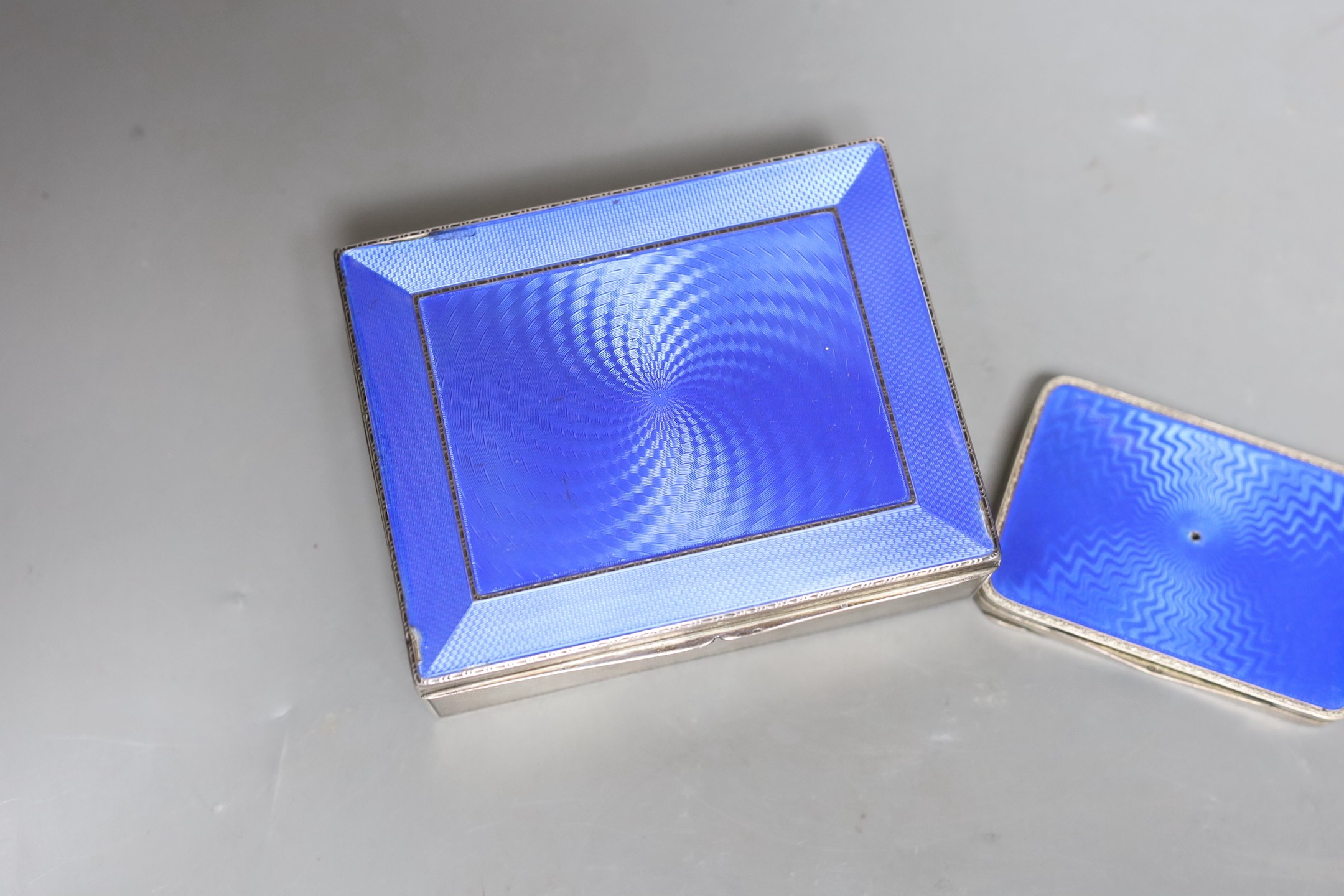 A George V silver and blue enamel cigarette box, import marks for London, 1928, 11.3cm and a Swedish white metal and enamel compact.